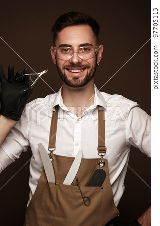 Manicur master man in working form with tools in hand. Nail photo content 97705113