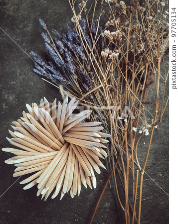 Wooden sticks, a tool for manicure on a background of flowers. Nail salon. Wooden sticks, a tool for manicure on a background of flowers. Nail salon. 97705134