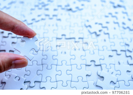 Scattered jigsaw puzzle background texture Hand holding one piece Strategy Clear blue 97706281