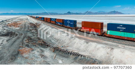 Cargo train passing by the desert Nevada, USA near Salt Flats. A railroad car is a vehicle used for the carrying of cargo on a railway. 97707360