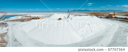 Salt Lake City, Utah landscape with desert salt mining factory at lake Bonneville with piles of white mineral and industrial equipment 97707364