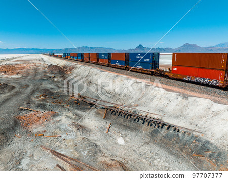 Cargo train passing by the desert Nevada, USA near Salt Flats. A railroad car is a vehicle used for the carrying of cargo on a railway. 97707377