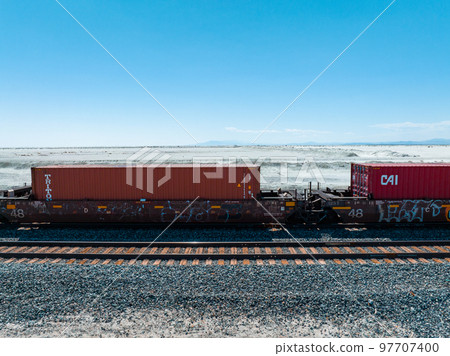 Cargo train passing by the desert Nevada, USA near Salt Flats. A railroad car is a vehicle used for the carrying of cargo on a railway. Cargo train passing by the desert Nevada, USA near Salt Flats. A railroad car is a vehicle used for the carrying of cargo on a railway. 97707400
