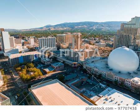 Panoramic aerial view of the city of Reno cityscape in Nevada. Downtown Reno, Nevada, with hotels, casinos and the surrounding High Eastern Sierra foothills. 97707438