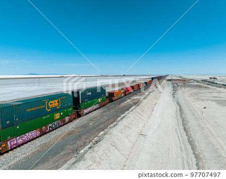 Cargo train passing by the desert Nevada, USA near Salt Flats. A railroad car is a vehicle used for the carrying of cargo on a railway. 97707497