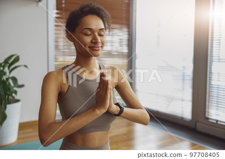 Woman taking online yoga class from home. Female engaged in webcam meditation practice on computer 97708405