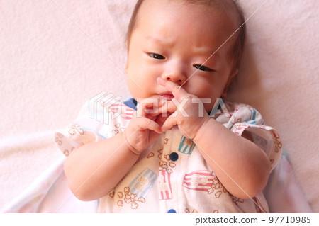 3 months old baby looking at his hand 3 months old baby looking at his hand 97710985