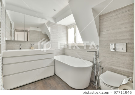 Modern home interior design of white bathroom with open bathtub and shower separated from toilet by partition wall 97711946