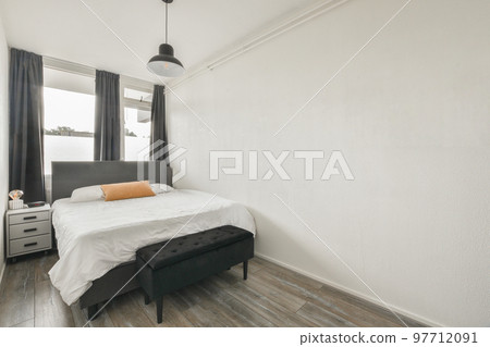 Comfortable bed placed near green wall in modern minimalist style mansard bedroom with windows Comfortable bed placed near green wall in modern minimalist style mansard bedroom with windows 97712091