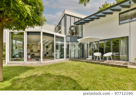 Neat paved patio with sitting area and small garden near wooden fence Neat paved patio with sitting area and small garden near wooden fence 97712290