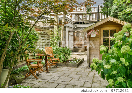 Neat paved patio with sitting area and small garden near wooden fence Neat paved patio with sitting area and small garden near wooden fence 97712681