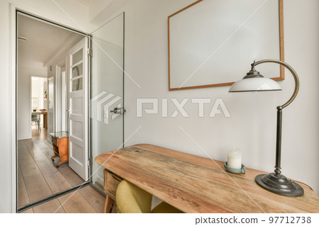 Minimalist interior of study room with parquet floor and white walls furnished with settee and table with shelf rack 97712738