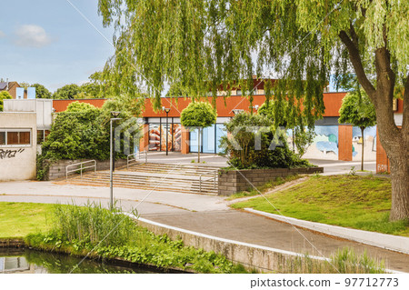 Panorama view of brick houses from an empty sidewalk street with cars, trees and lanterns Panorama view of brick houses from an empty sidewalk street with cars, trees and lanterns 97712773