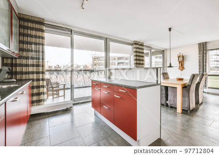 Counters with stove and oven located in modern kitchen near dining room at home 97712804