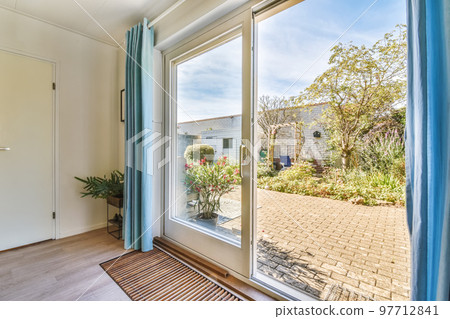 an outside view from the inside of a room with sliding glass doors and blue drapes hanging on the wall 97712841
