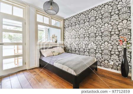 Home interior design of bedroom with bed and wooden wardrobe placed in corner near window in modern apartment Home interior design of bedroom with bed and wooden wardrobe placed in corner near window in modern apartment 97712859