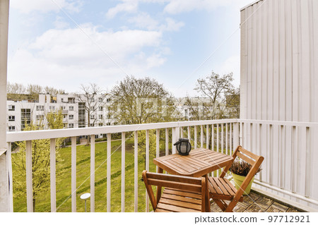 Front view of old brick buildings and cars with bicycles from small balcony with railings 97712921