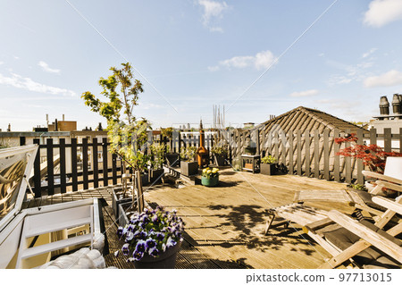 Bright wooden balcony with metal railings, wooden chair and door Bright wooden balcony with metal railings, wooden chair and door 97713015