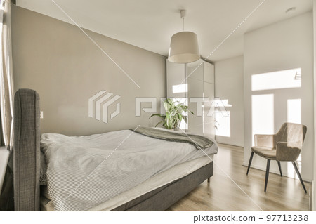Comfortable bed located near window with curtain in light bedroom of contemporary flat Comfortable bed located near window with curtain in light bedroom of contemporary flat 97713238