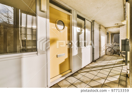 Corridor of contemporary apartment with black closets and opened doorway leading to terrace Corridor of contemporary apartment with black closets and opened doorway leading to terrace 97713359