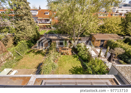 Front view of old brick buildings and cars with bicycles from small balcony with railings 97713710