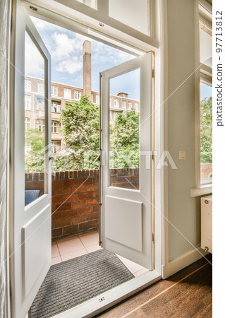 Narrow brick balcony with metal railings, wooden chair and door Narrow brick balcony with metal railings, wooden chair and door 97713812