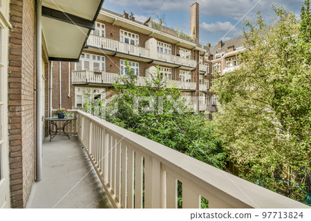 Narrow brick balcony with metal railings and door Narrow brick balcony with metal railings and door 97713824