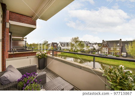 Panoramic view of old brick buildings with parking and trees from small balcony 97713867