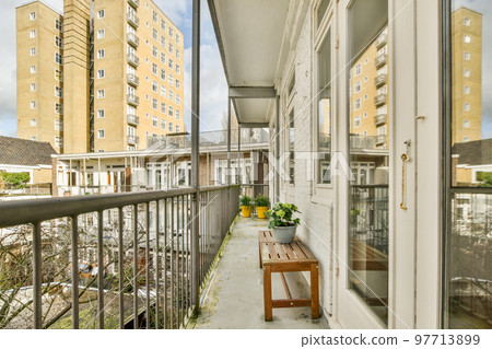 Front view of old brick buildings and cars with bicycles from small balcony with railings 97713899
