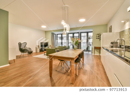 Studio apartment with white walls and open plan kitchen and dining zone with sofa in living room Studio apartment with white walls and open plan kitchen and dining zone with sofa in living room 97713913