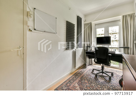 Comfortable chair placed near desk with computer monitors and whiteboard in light workplace in modern apartment Comfortable chair placed near desk with computer monitors and whiteboard in light workplace in modern apartment 97713917