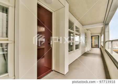 Corridor of contemporary apartment with black closets and opened doorway leading to terrace Corridor of contemporary apartment with black closets and opened doorway leading to terrace 97713918