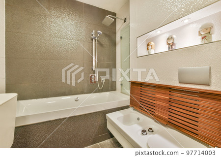 Sinks with mirrors and clean bathtub in modern bathroom with white tiled walls 97714003