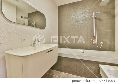 Sinks with mirrors and clean bathtub in modern bathroom with white tiled walls 97714005