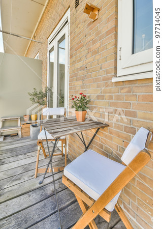 Front view of buildings and cars with bicycles from small balcony with railings 97714045