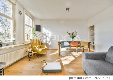 Couches and table located near TV against dining area of spacious room in contemporary apartment 97714065