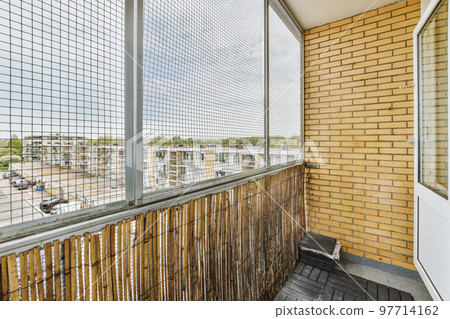Narrow brick balcony with metal railings and door 97714162