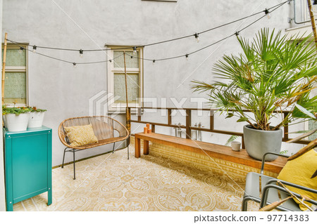 a living room with plants on the wall and an outdoor kitchen area in the corner, which is decorated with string lights 97714383