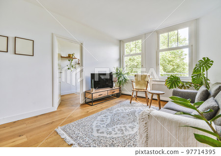 Comfortable sofa with cushions placed against light wall with TV and decorations in modern loving room 97714395