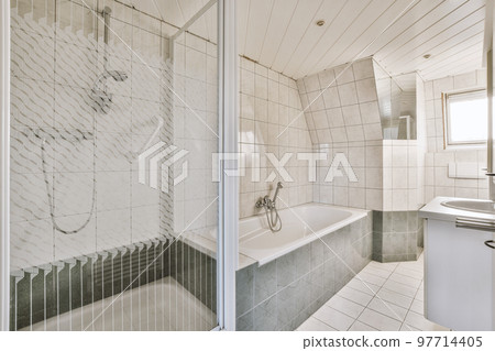 Sinks with mirrors and clean bathtub located near shower box with glass door in modern bathroom with white tiled walls 97714405