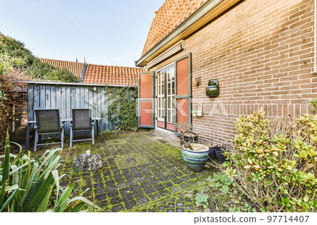 Neat patio with sNeat paved patio with sitting area and small garden near wooden fenceitting area 97714407