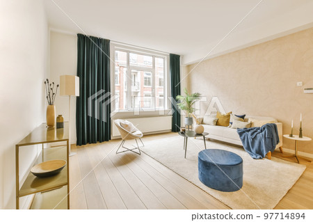 a living room with wood flooring and white walls, including a large window that looks out onto the street 97714894