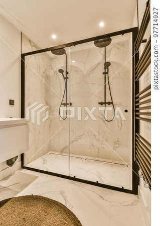 a modern bathroom with marble flooring and black trim on the shower door, along with a round rug in front a modern bathroom with marble flooring and black trim on the shower door, along with a round rug in front 97714927