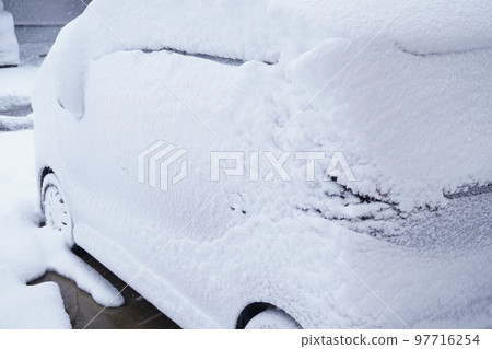 A photo of a snow country landscape with snow piled up on a car 97716254