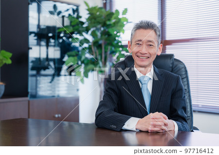 Business man sitting on a chair with a smile Business man sitting on a chair with a smile 97716412