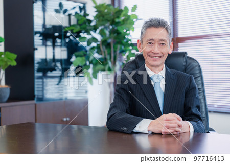 Business man sitting on a chair with a smile Business man sitting on a chair with a smile 97716413