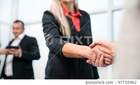 close up. confident business people shaking hands with each other 97716962