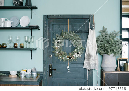 Christmas wreath on the wooden door in the kitchen in Scandinavian style in blue tones 97718218