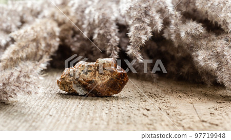 Raw andradite rock mineral sample on wood Raw andradite rock mineral sample on wood 97719948