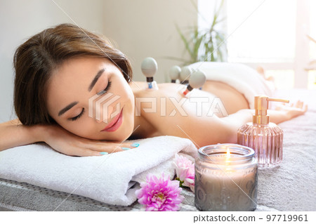 Cupping vacuum massage treatment for beautiful asian woman. Cupping massage enhances lymphatic drainage and blood flow to the tissues and eliminates fatigue and back pain. 97719961
